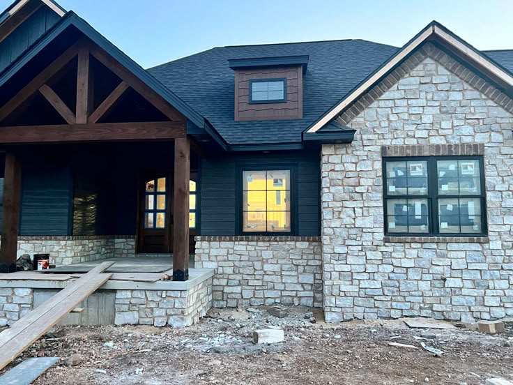 A navy house with stone wal and wooden plllar