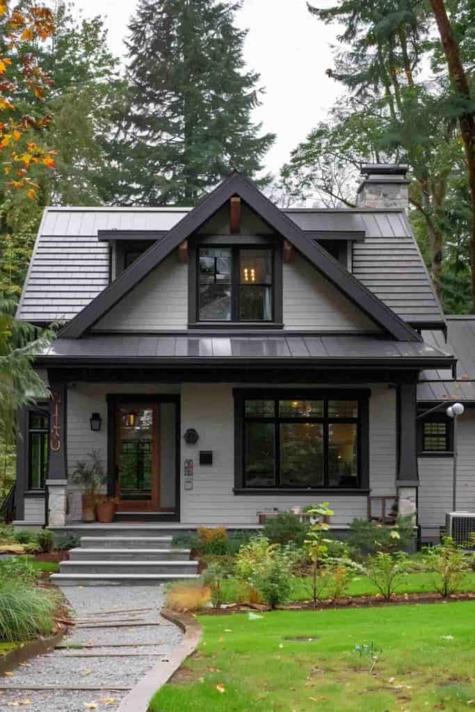 A grey house with stone pathway and black trim windows
