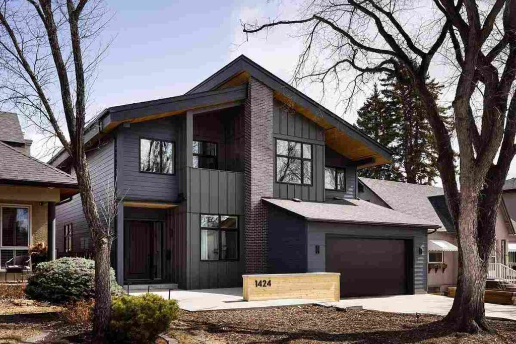 A grey house with windows and wooden garage door