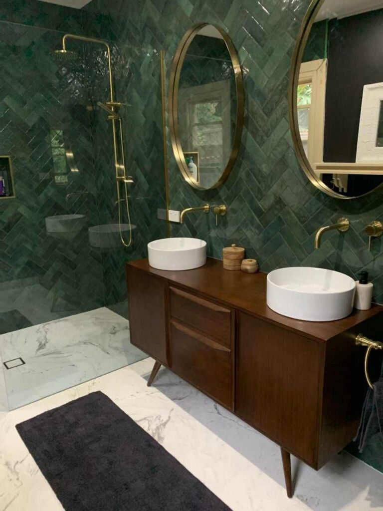 A green bathroom with white floating sink and fixture