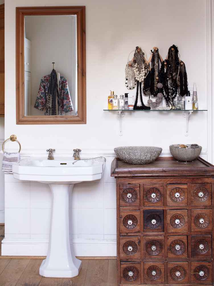 A apothecary cabinet and white sink with gold fixture
