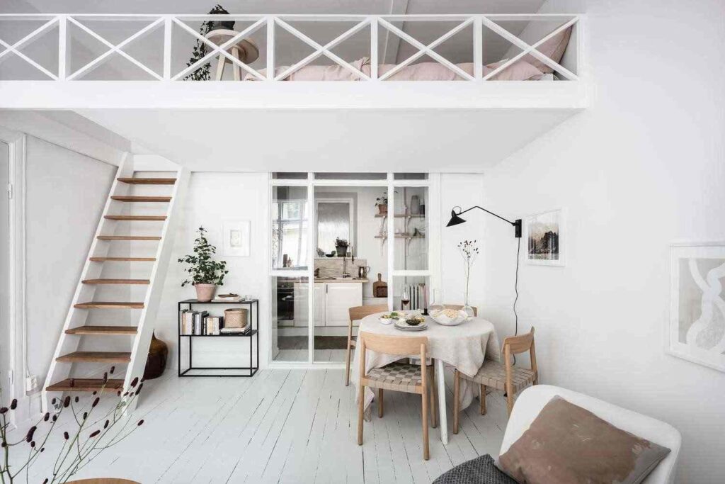 A white loft bed with stair and dinning table in the bedroom