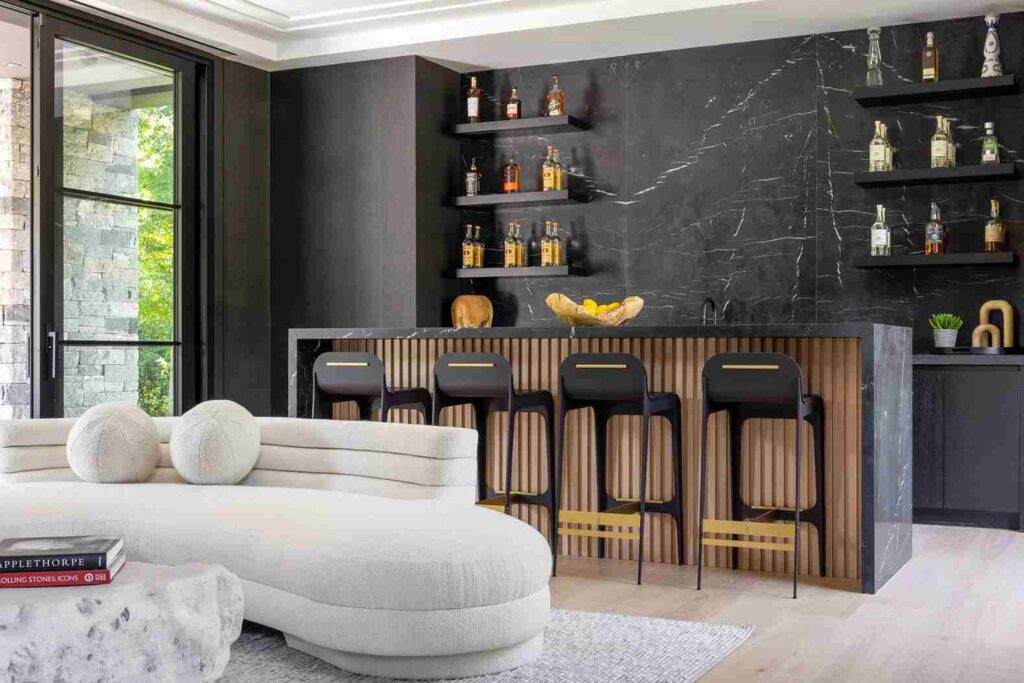 A living room with bar area with wooden deck and chair in the room and white sofa and wooden floor 