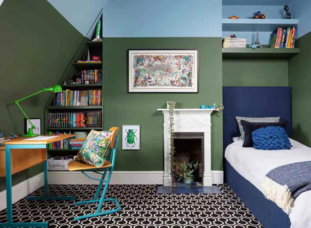 A green and blue bedroom with floor and wooden study table 