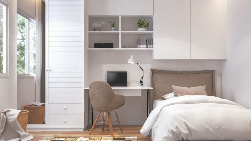 A bedroom with functional storage and study table 