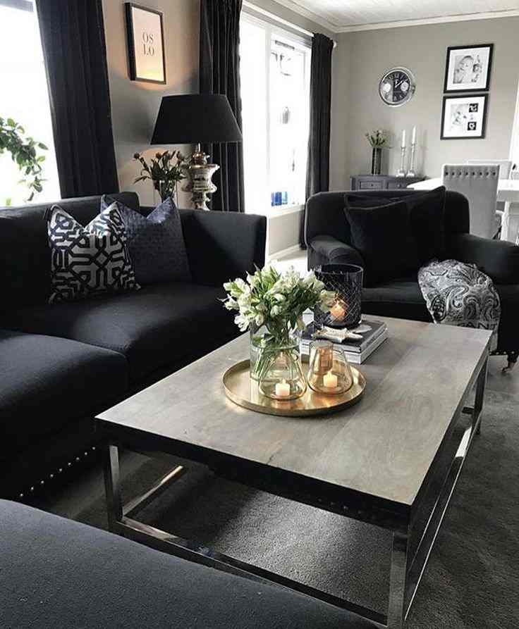 A black and grey living room with table and sofa and frames on the wall 