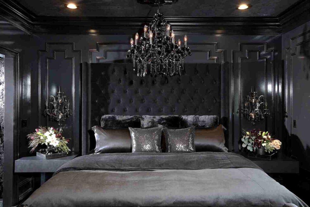 A bedroom with black crystal chandelier and grey blankets with pillow