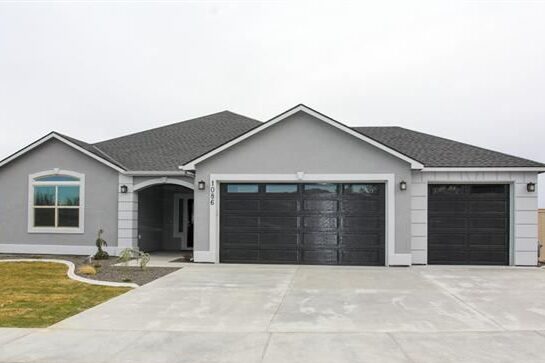 A grey house with black garage with white trim