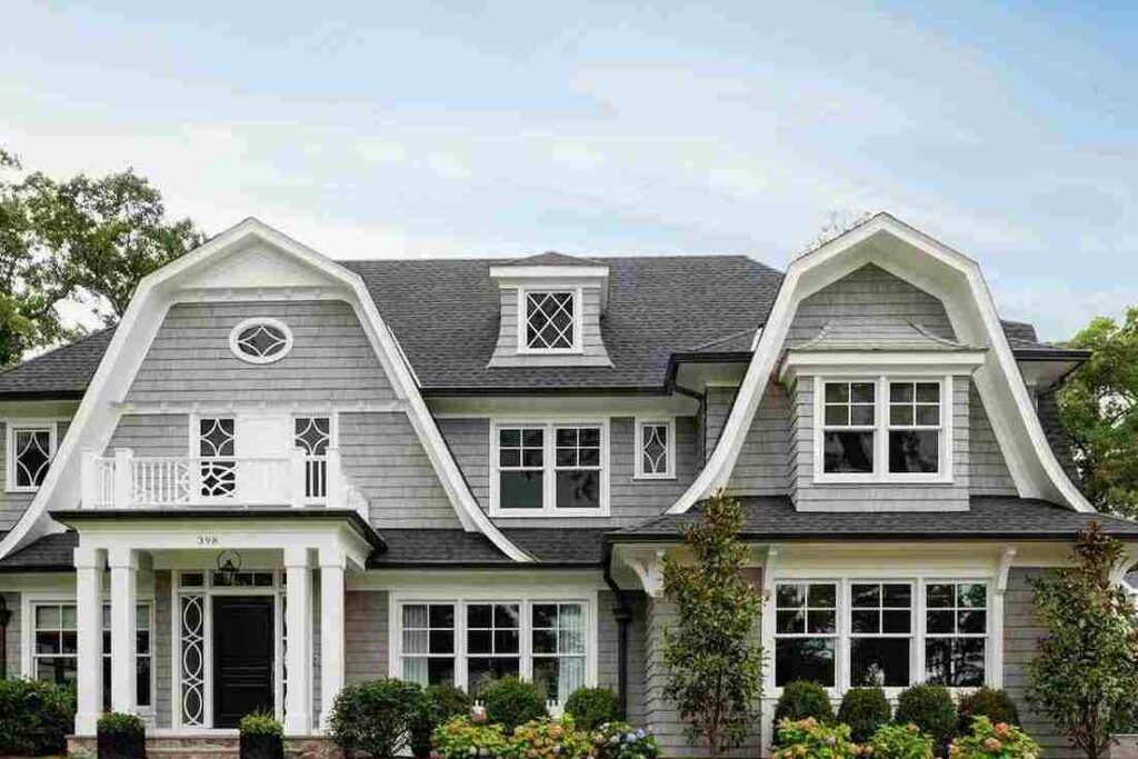 A grey house with black trim and white windows and black front door