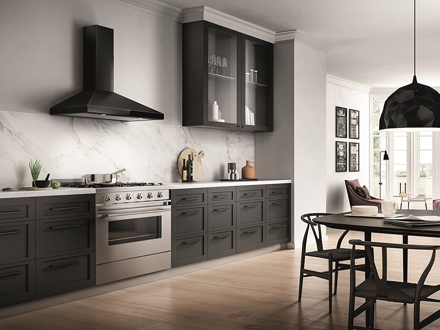 A black kitchen with wooden floor and black vent hood