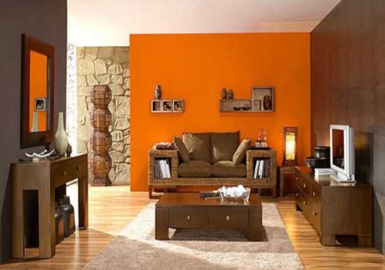 A brown and orange with stone wall and wooden floor and rug on it 