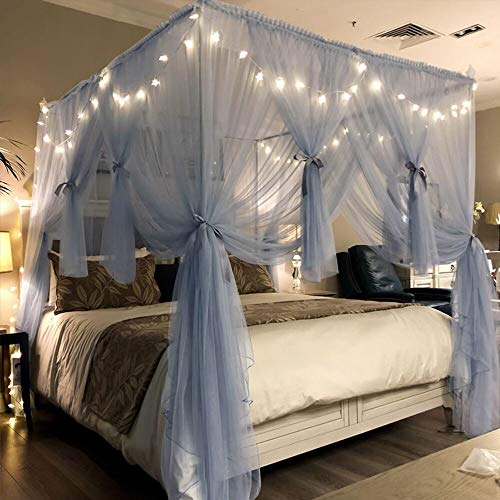 A bedroom with canopy bed with drapes