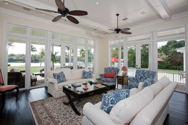 A celling fan and sunroom and sofa with table and rug on the floor 