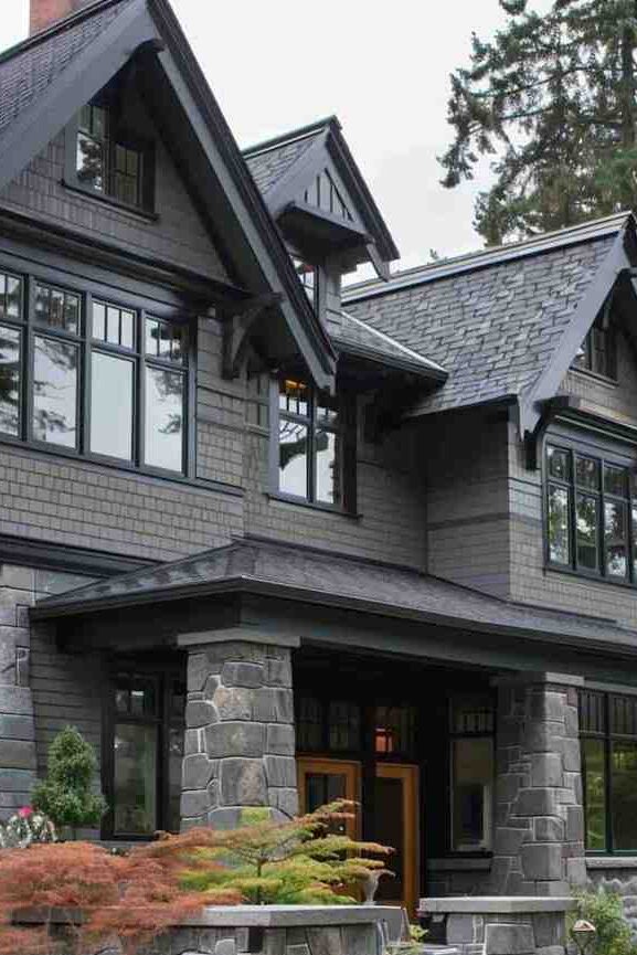 A charcoal grey house with black trim and windows 