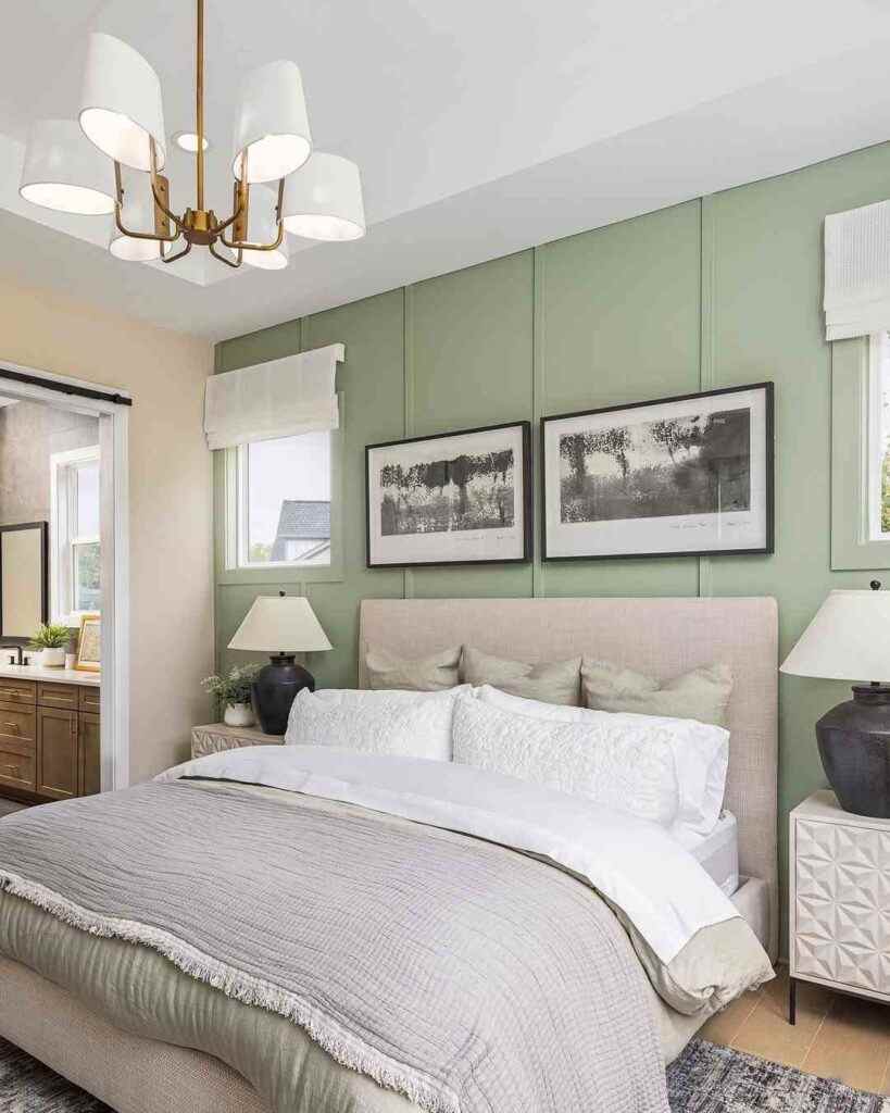 A beige bedroom with sage accents bedroom with frames on the wall