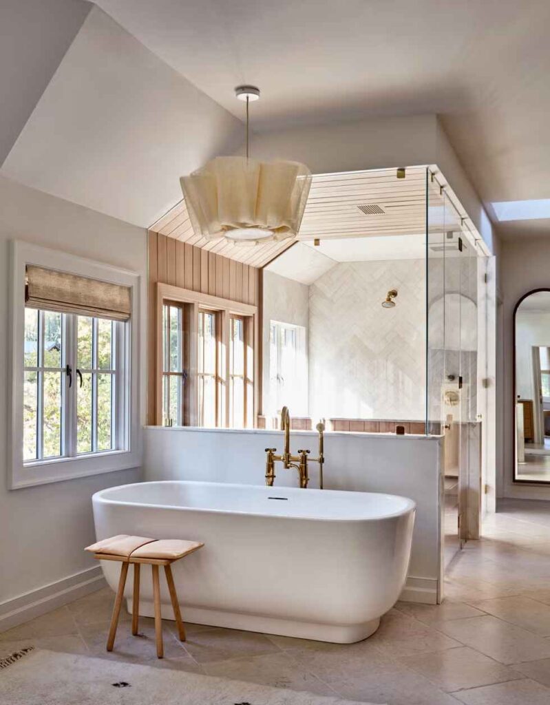 A bathroom with windows treatment and wooden floor and glass shower door