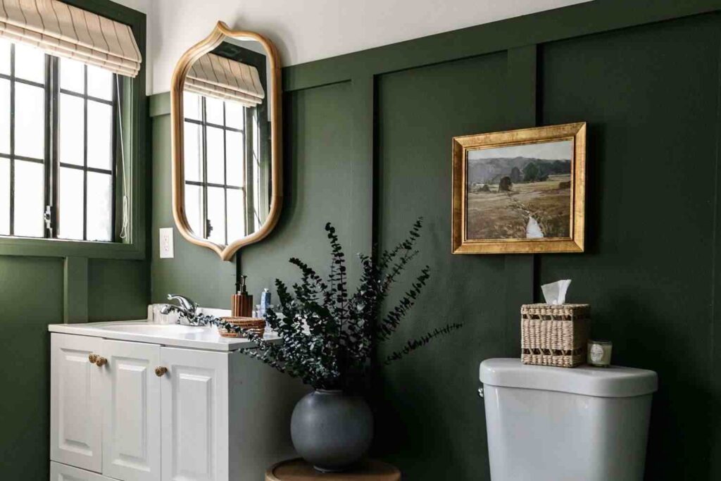 A green bathroom with white vanity and mirror on the wall