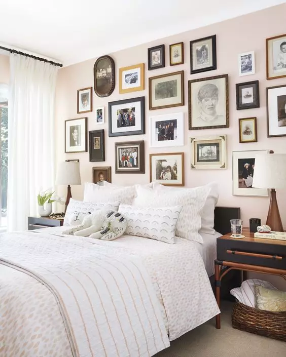 A gallery wall in bedroom with white blankets and pillow and cushion 
