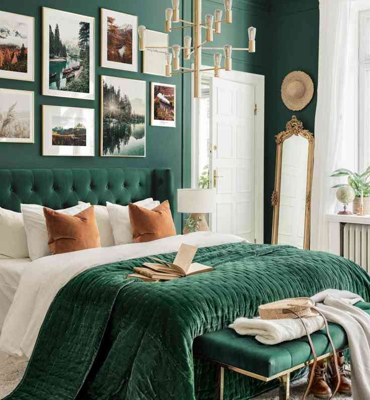 A green bedroom with gallery wall and gold framed mirror and