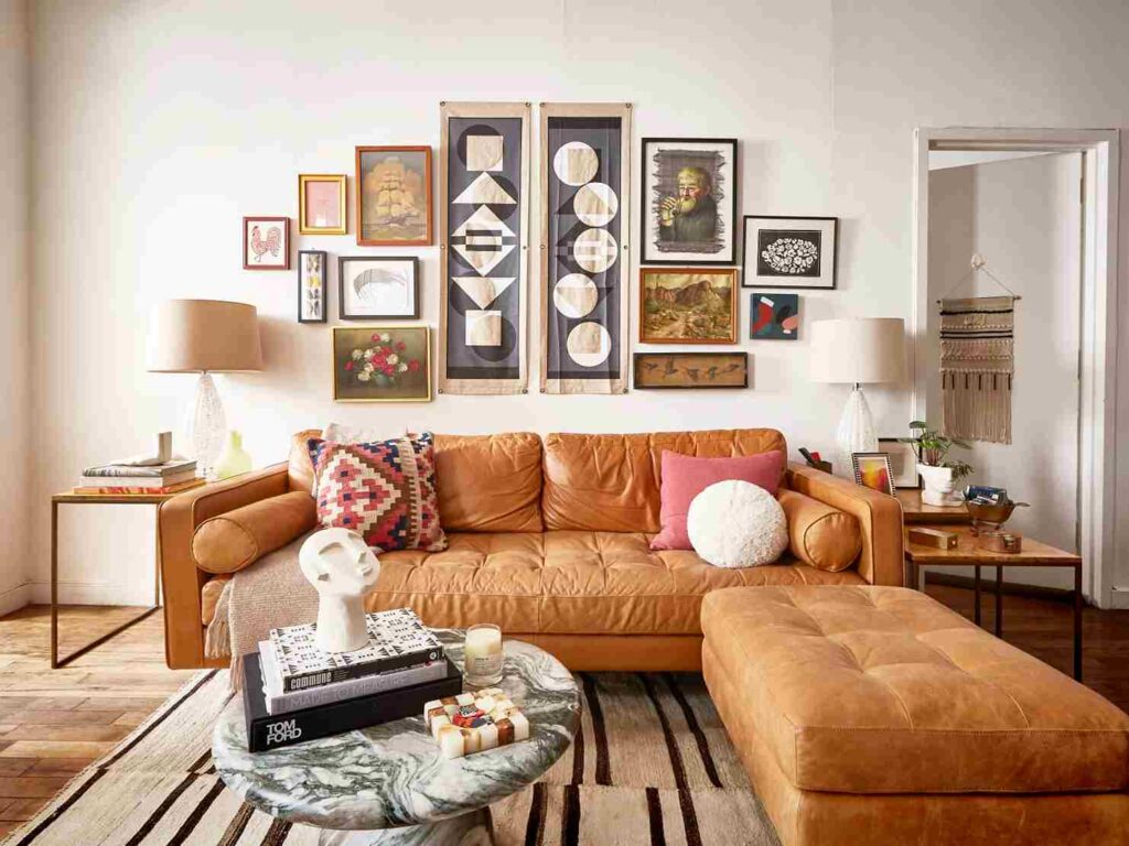 A living room with sofa and ottoman and gallery wall 