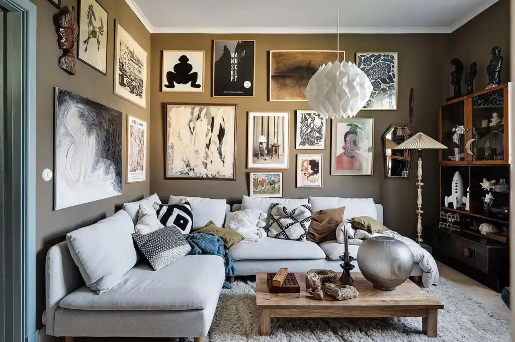 A brown living room with grey sofa and wooden table and gallery wall 