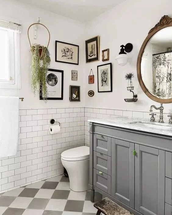 A bathroom with gallery wall with artwork and wooden frames mirror