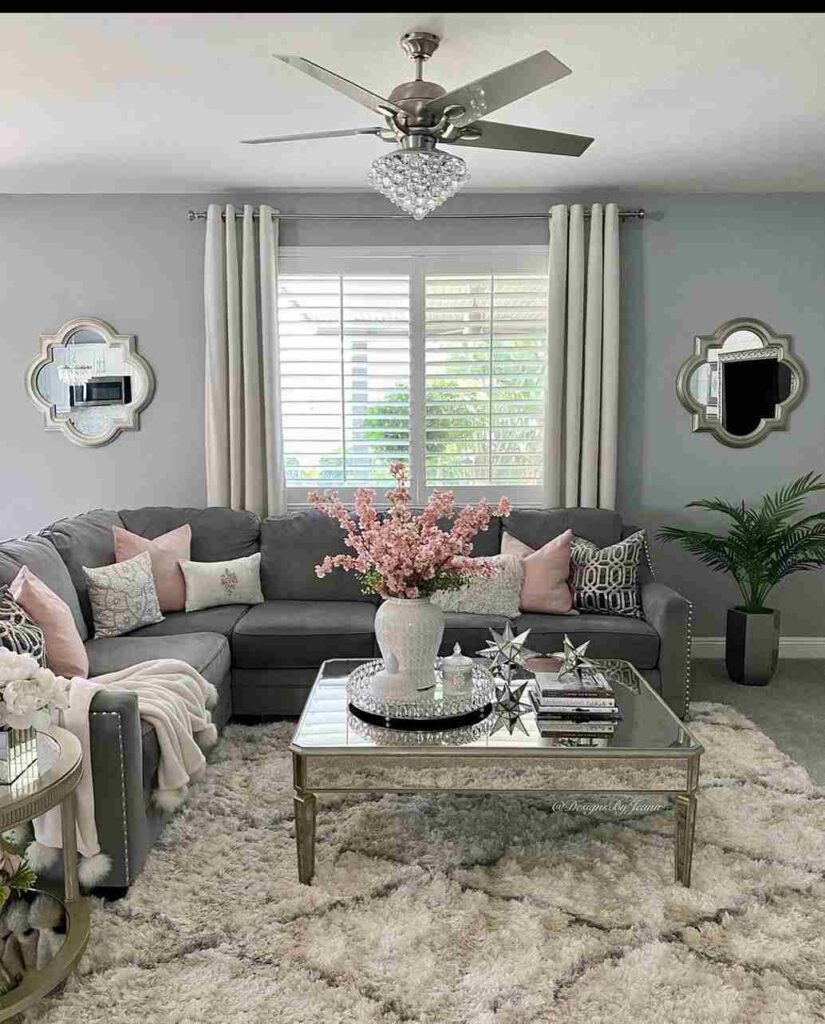 A grey living room with sofa and glass table and rug on the floor 