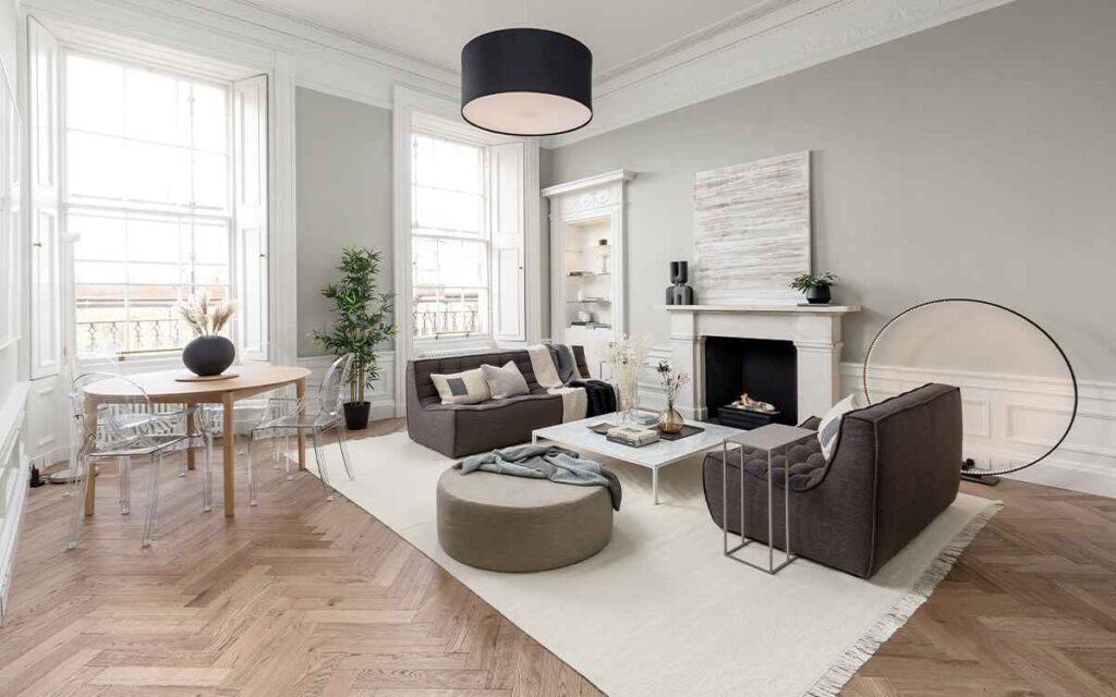 A grey living room with wooden floor and sofa and rug on the floor 