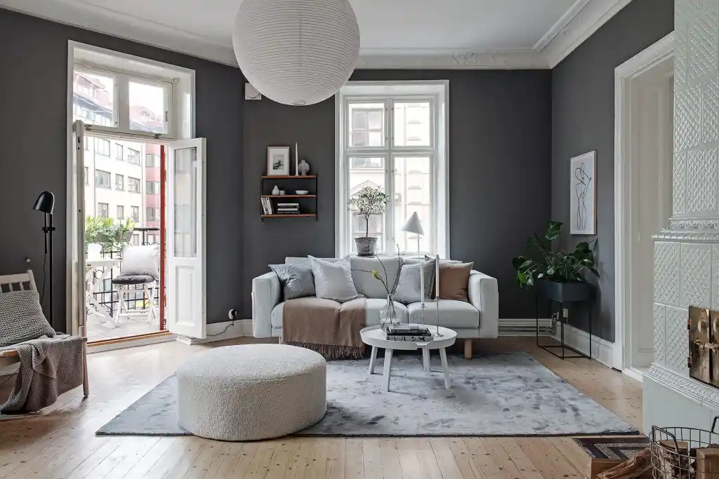 Grey living room with sofa and table and white windows and wooden floor and rug on it 
