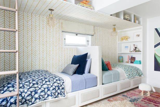 A white head to head bed with rug on the floor and small windows above the bed 