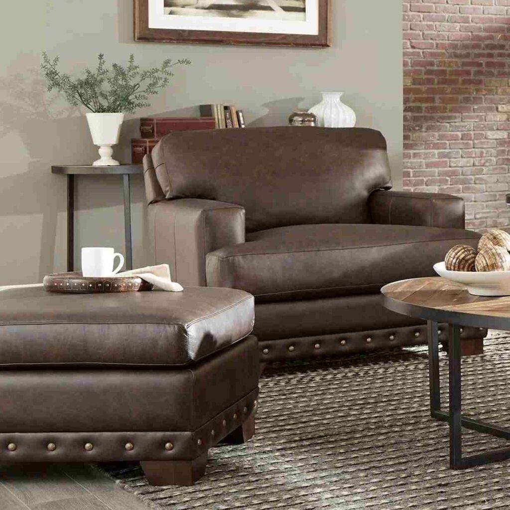 A grey living room with leather chair with ottoman 