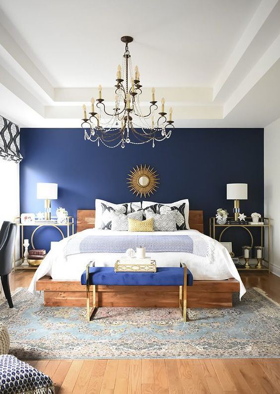 A navy blue bedroom with wooden bed ad wooden floor and rug on it