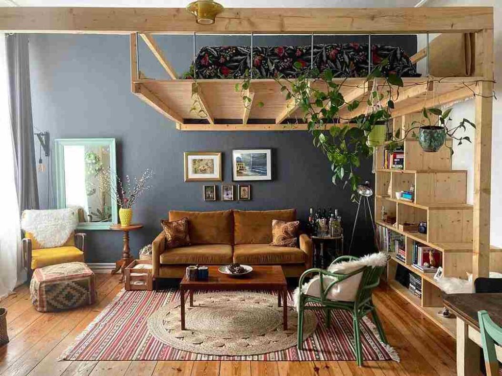 A wooden loft bed with sofa and mirror on the wall and sitting area