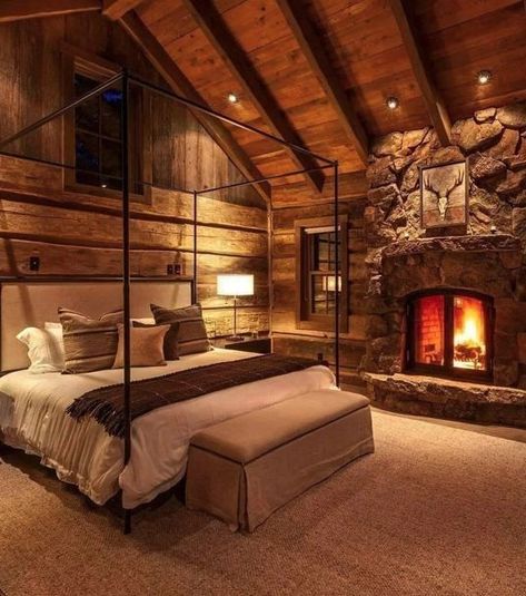 A log cozy bedroom with fireplace and bed with cushion