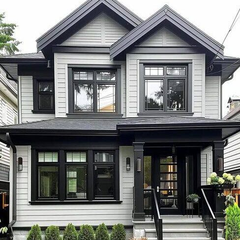 A light grey house with black trim and widows