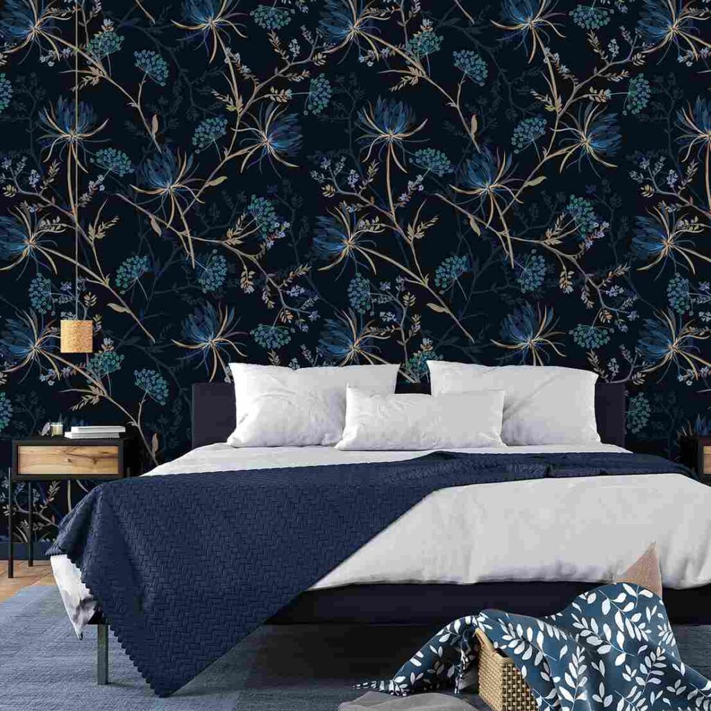 A navy blue bedroom with floral accents and white blankets and blue throw with pillow and cushion