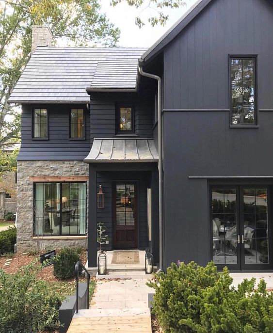 A navy blue house with black gutter and windows and door 