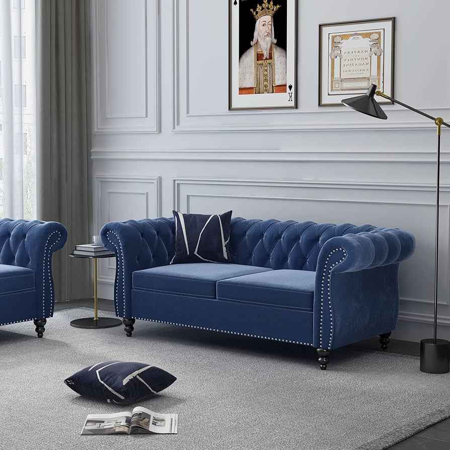 A grey living room with navy velvet sofa with cushion