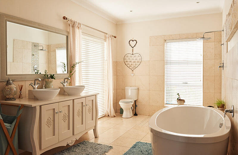 A bathroom with bathtub and vanity and mirror on the wall and white sink