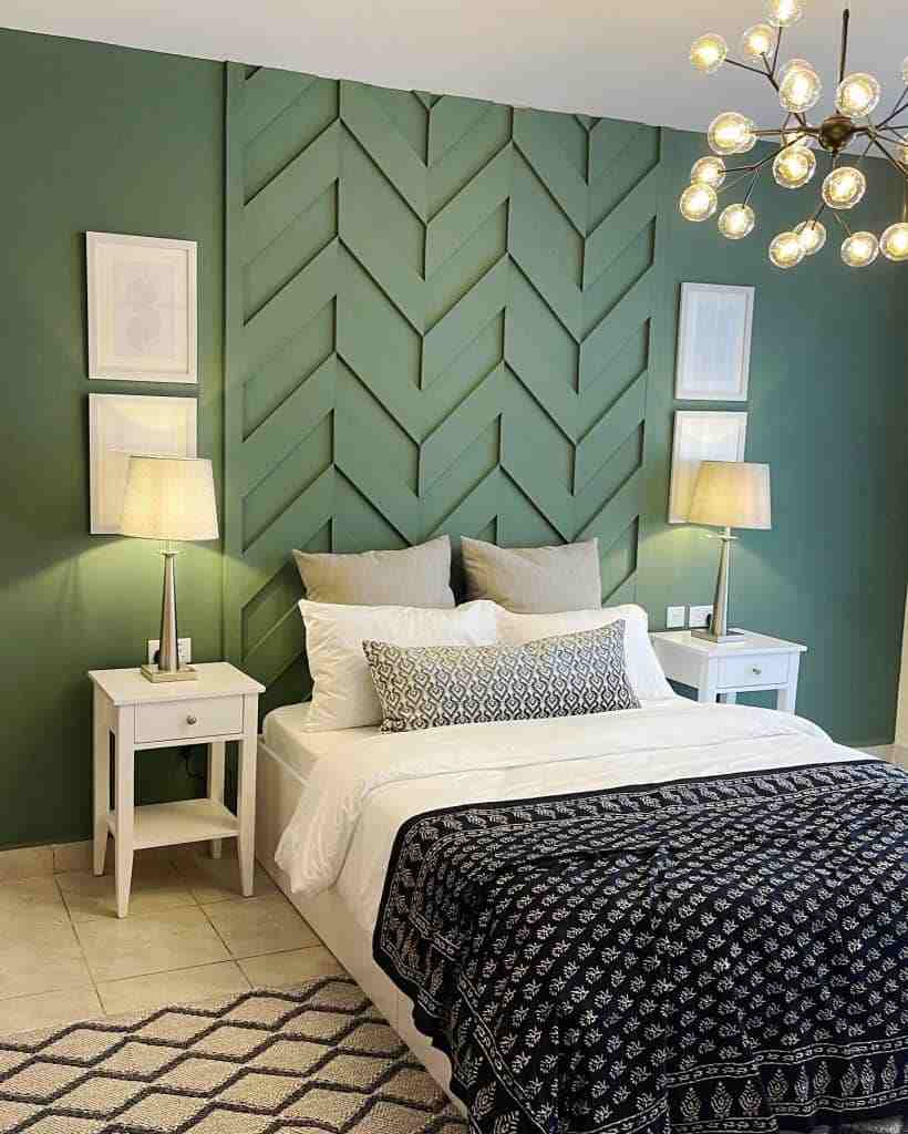 A olive green bedroom with accent wall and wooden floor and rug on it 