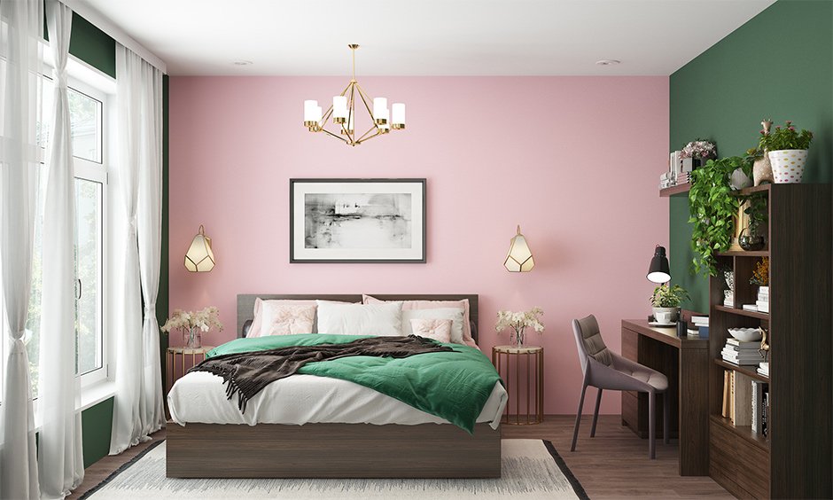 A pink and green bedroom with lights on the wall and wooden floor and rug on it