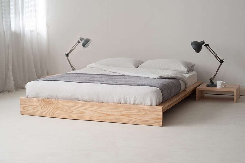 A loft bed with grey blanket and pillow and wooden white floor 