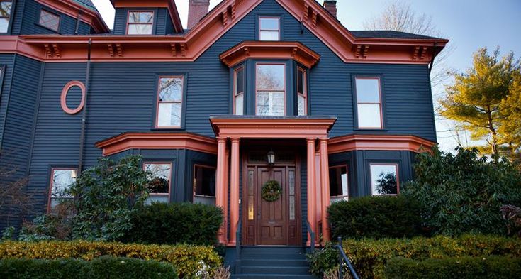 A red door on blue house and glass windows 