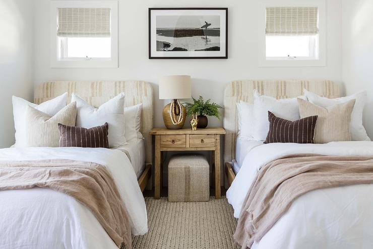 A lamp on the wooden deck and two beds brown throw with pillow and cushion
