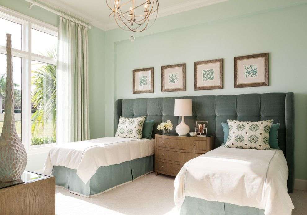 A shared upholstered headboard bed and shared wooden cabinets and frames on the wall 