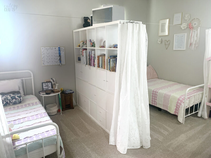A bedroom with divide and wooden floor