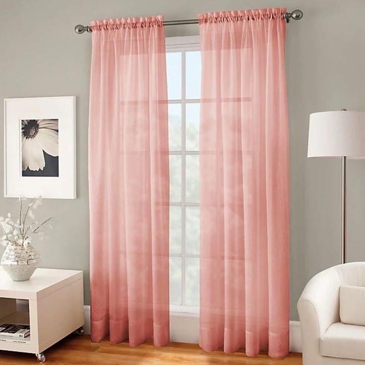 A grey living room with pink curtains and wooden floor 