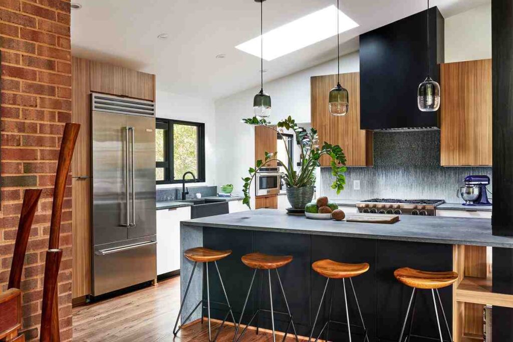 A black kitchen with wood accent and wooden floor and windows 