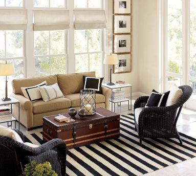 A sunroom with stripped rugs sofa with table 