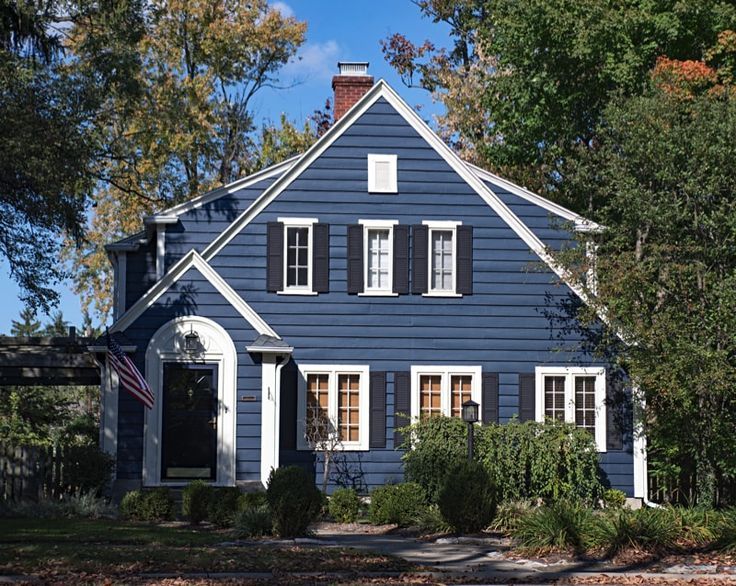 A navy house with white window and black shutters